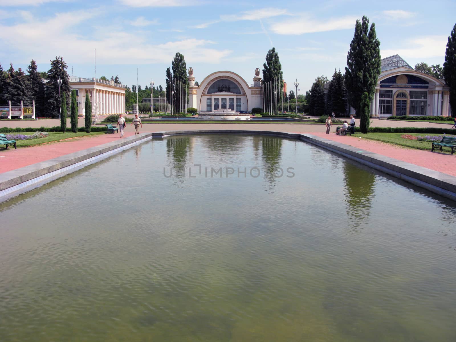 A huge, filled with water, a fountain against the background of ancient decorative buildings with pillars and stucco molding