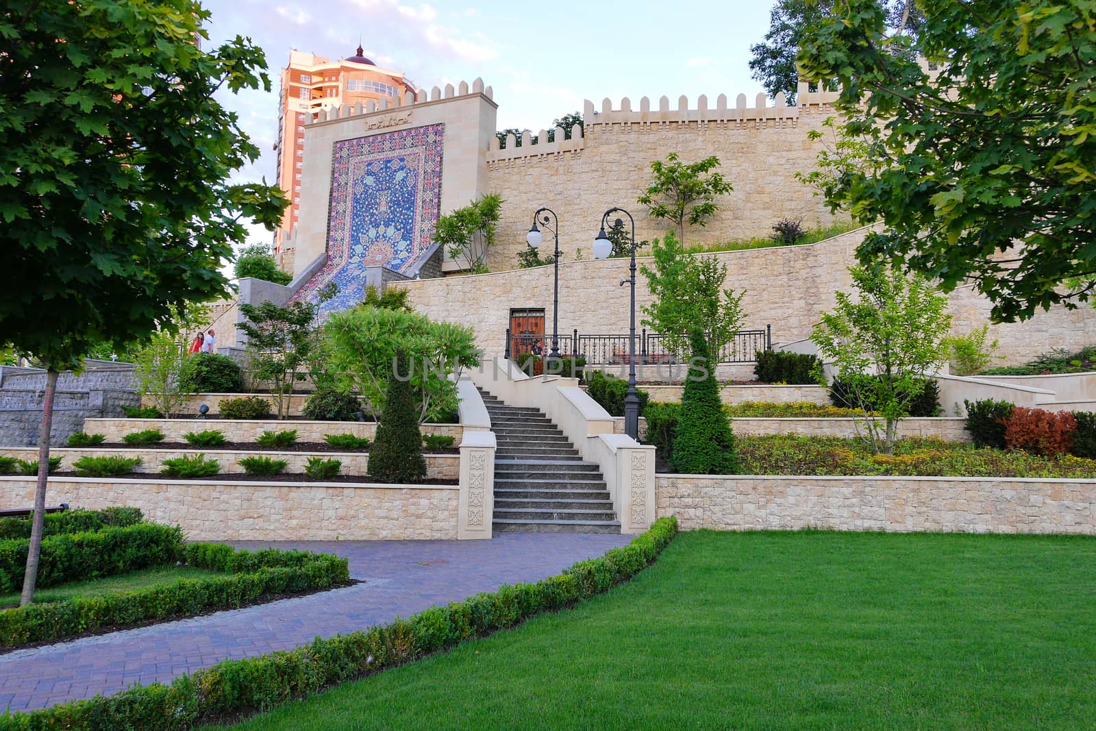 An ancient building with a staircase decorated with colored mosaics. Around the lawn. That is necessary for a photo to the tourist