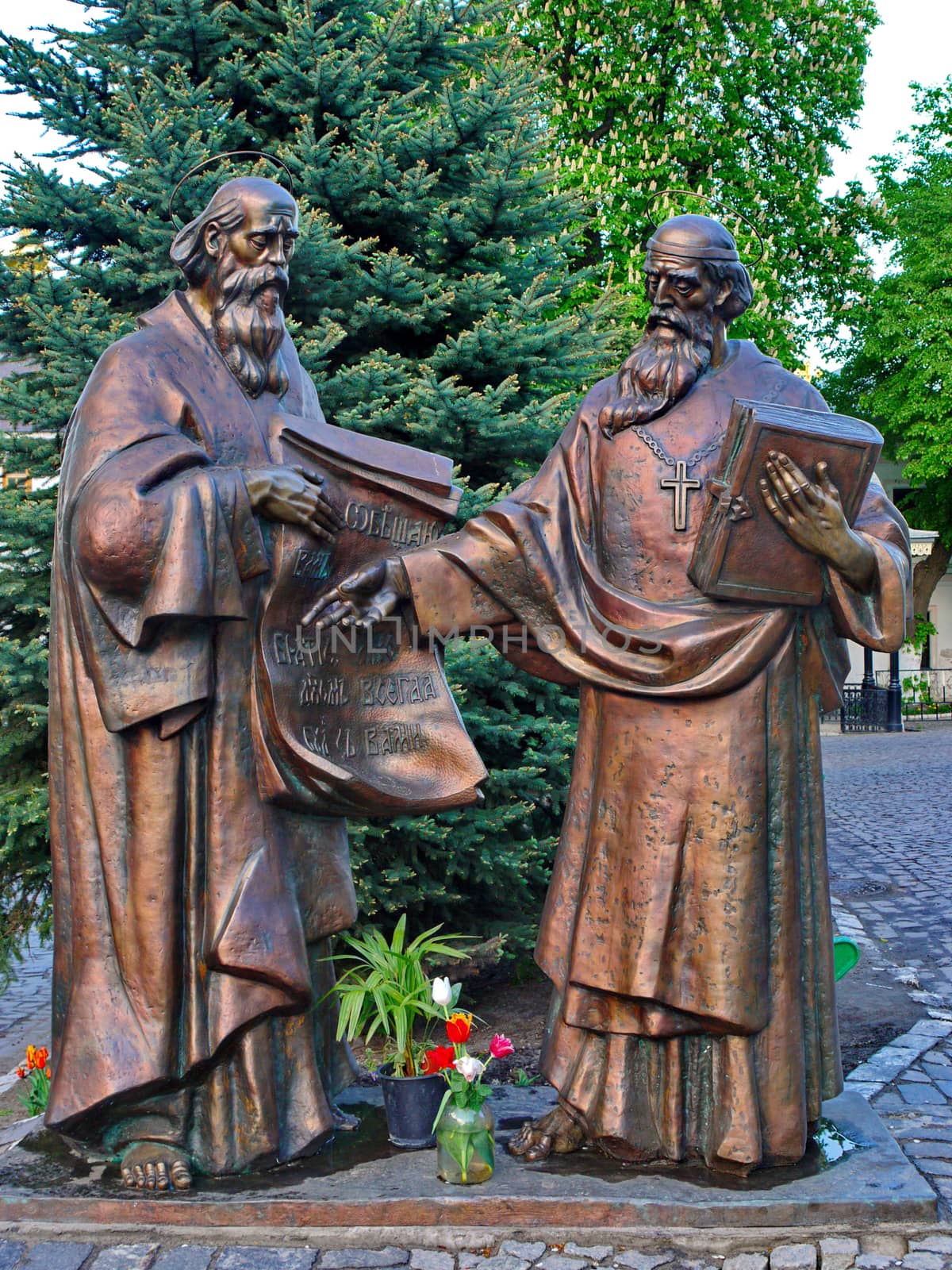 Sculpture of two saints of old age people with a cross on their necks and a book in the hands of one and sheets of manuscripts from the other.