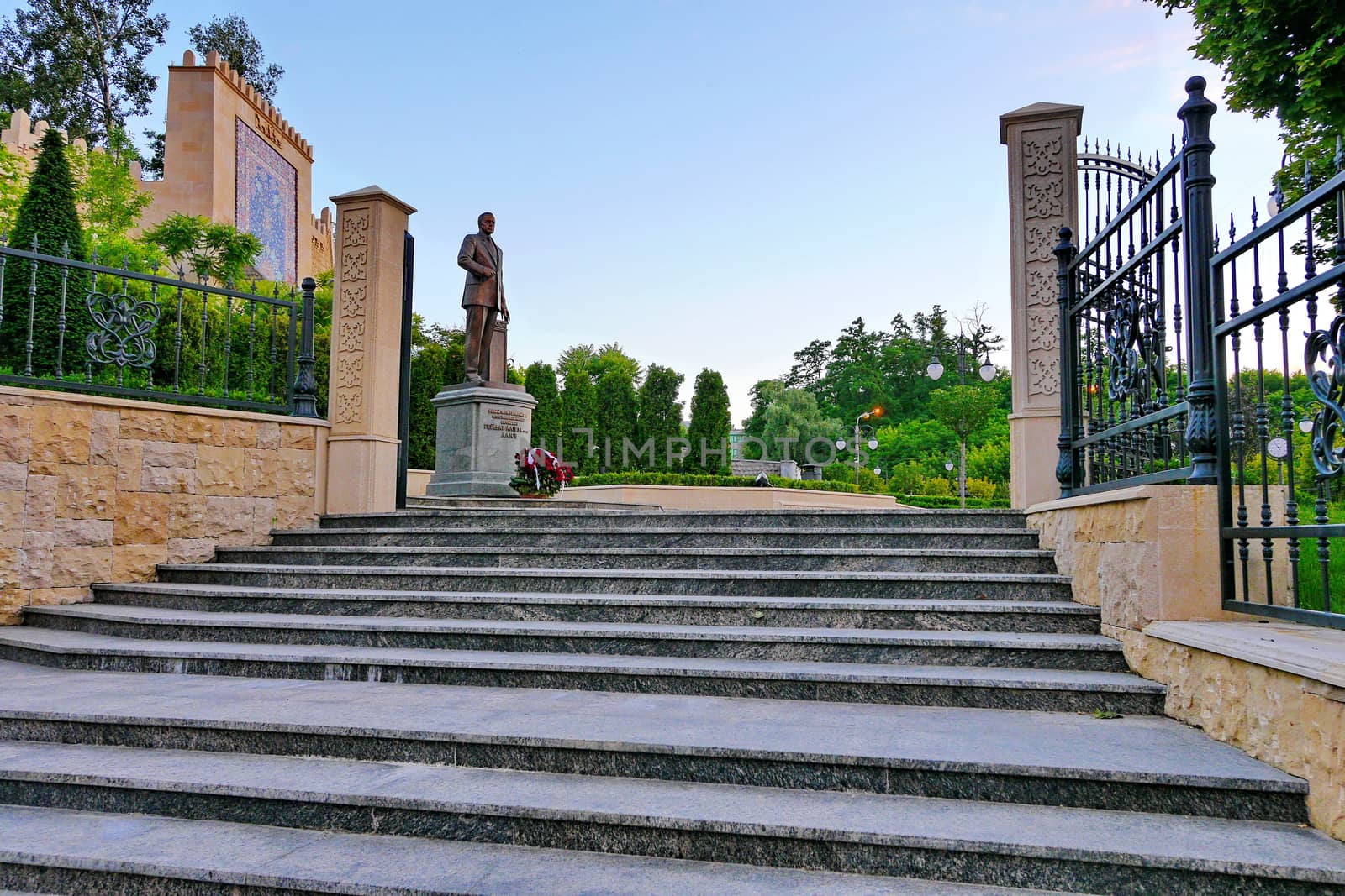monument with a bouquet of roses in the foreground at the entrance to the park
