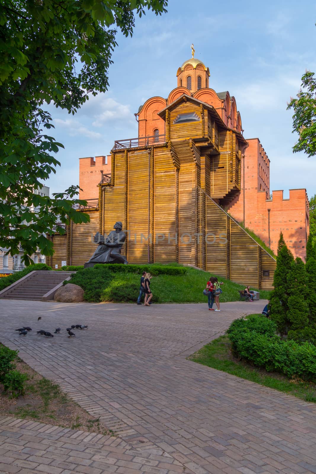 a monument of architecture and artwork Golden Gate in Kiev among green trees against the backdrop of the sunset cloudless sky. a place for recreation and tourism