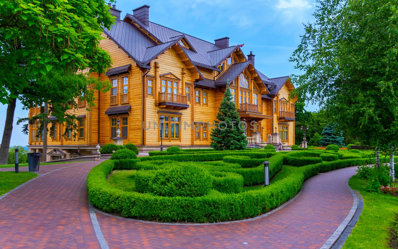 A beautiful wooden mansion from pine decks and a flowerbed in front of it