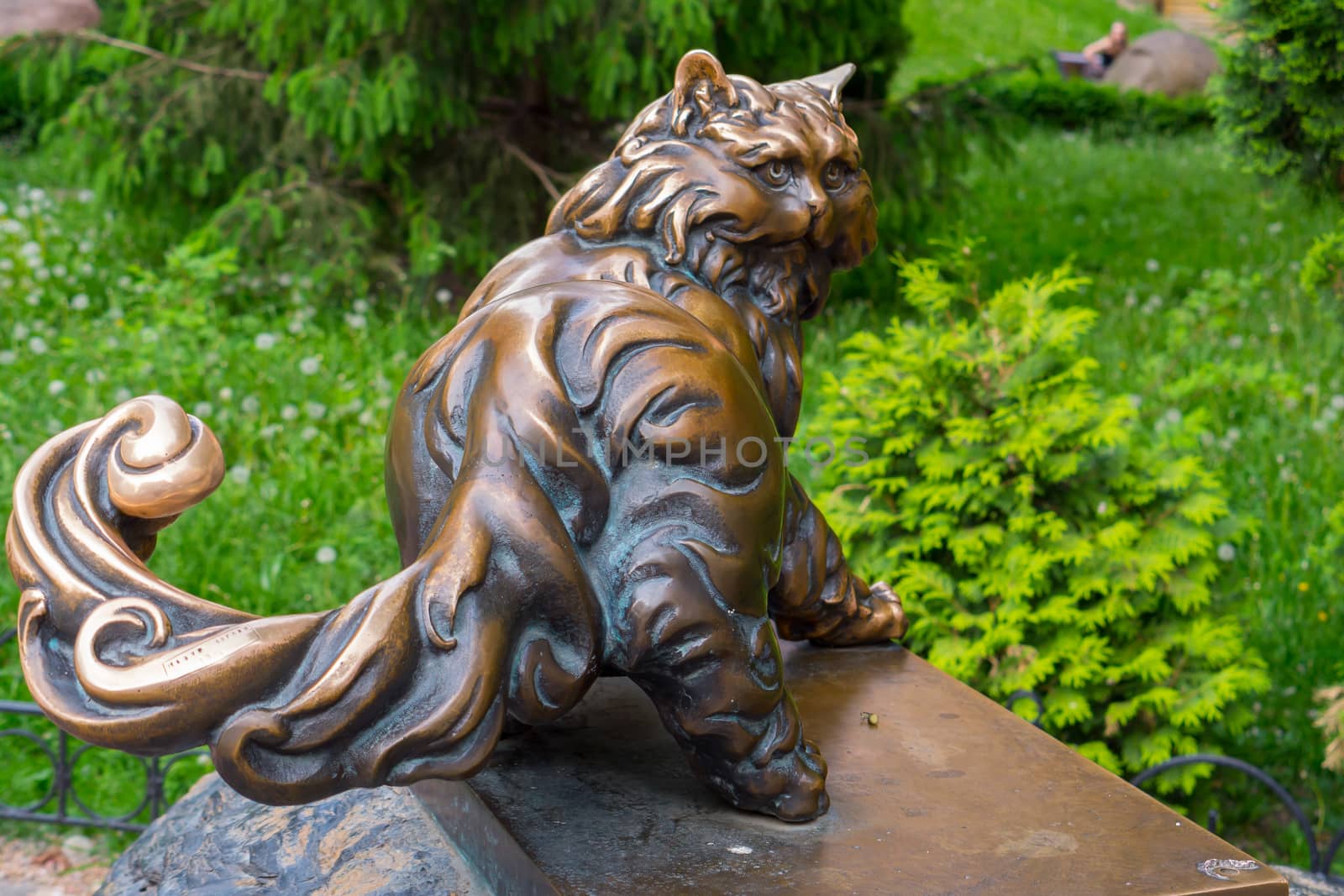 A copper monument to a large, pushy cat looking back