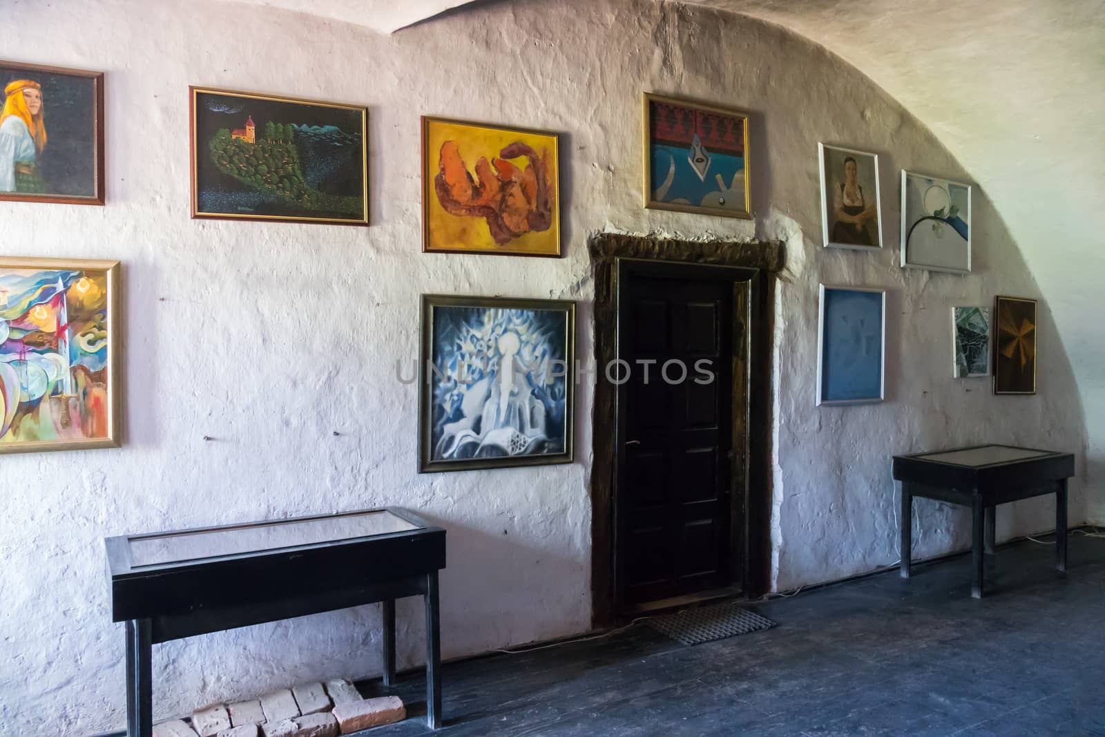 The museum room with several unusual paintings hung on the sides of the doors