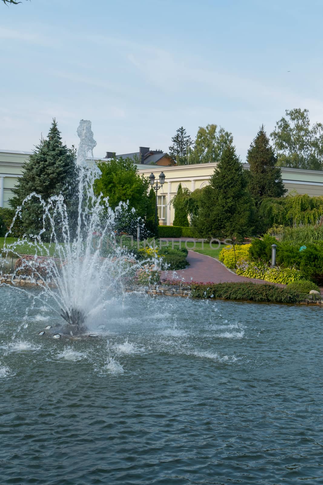 Lake with a beautiful beating fountain not far from pretty promenade alleys