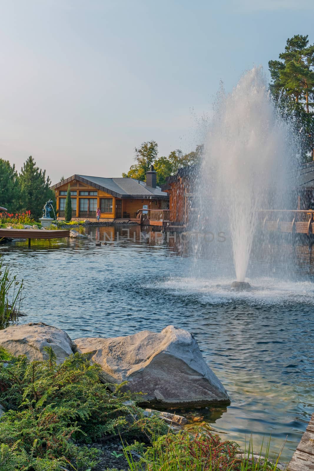 Beautiful decorative lake with a fountain on the background of the hotel complex