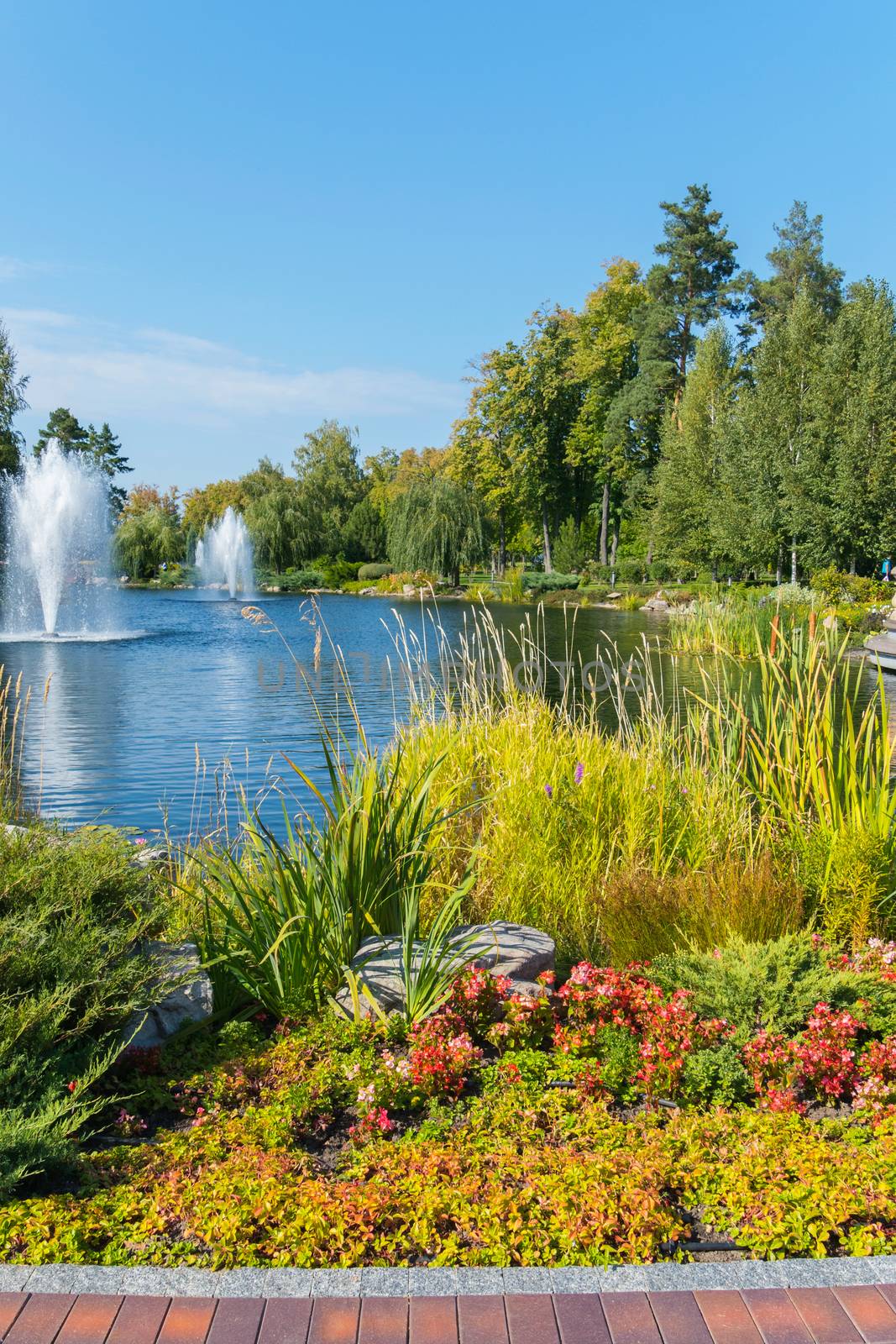 Park area with beautiful flower beds and a view of the lake with fonts