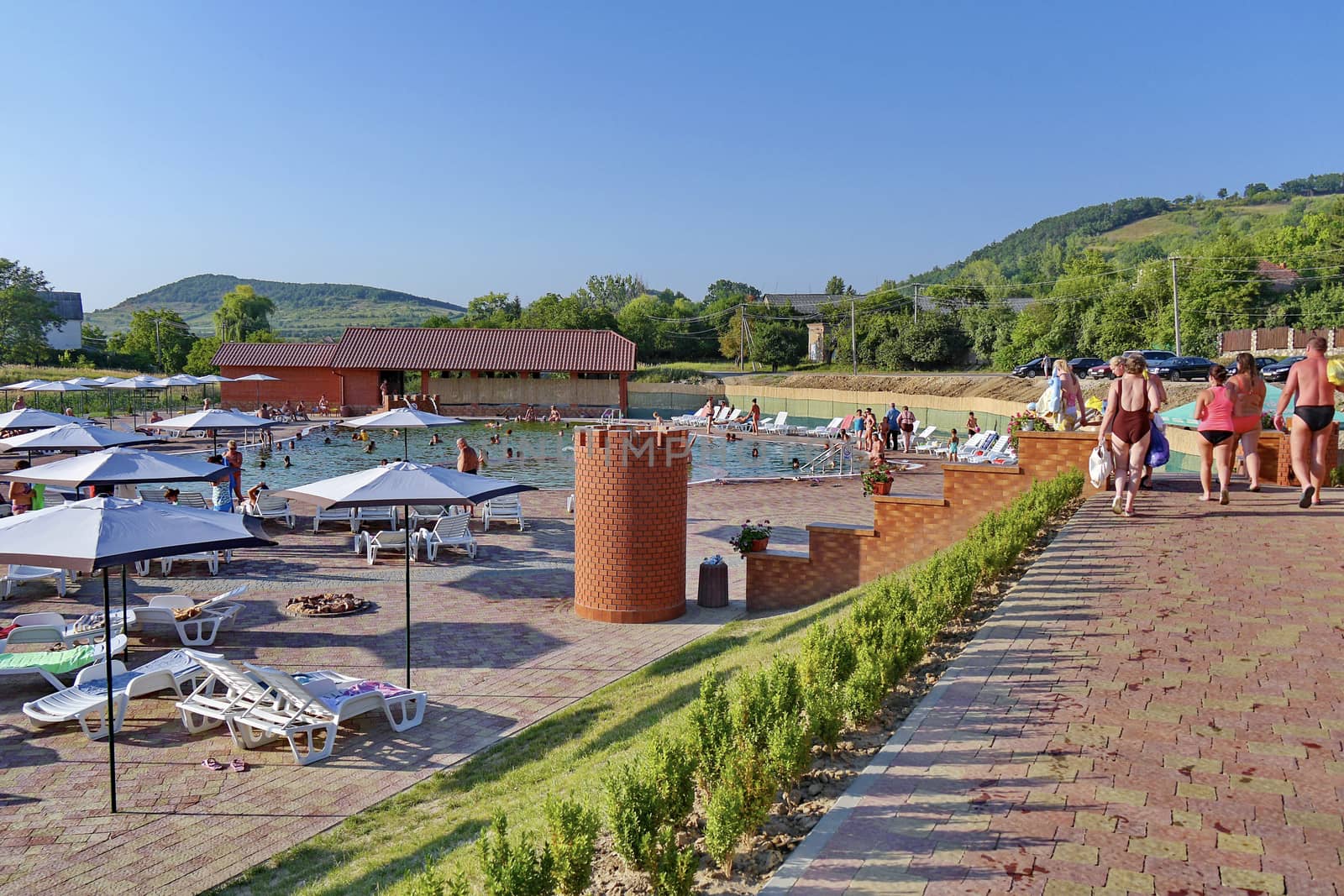 A large number of vacationers in the pool and on the sun loungers near it
