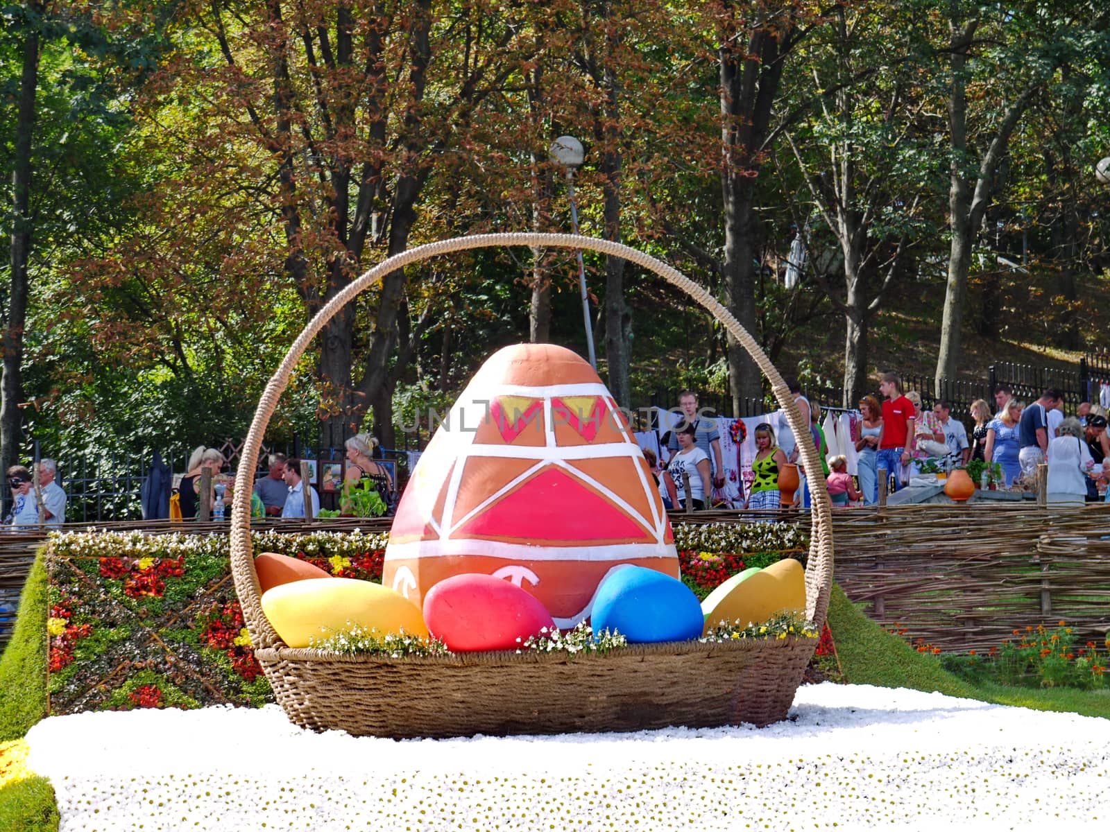 a large Easter basket with colorful eggs-krashenkami against the background of the fence