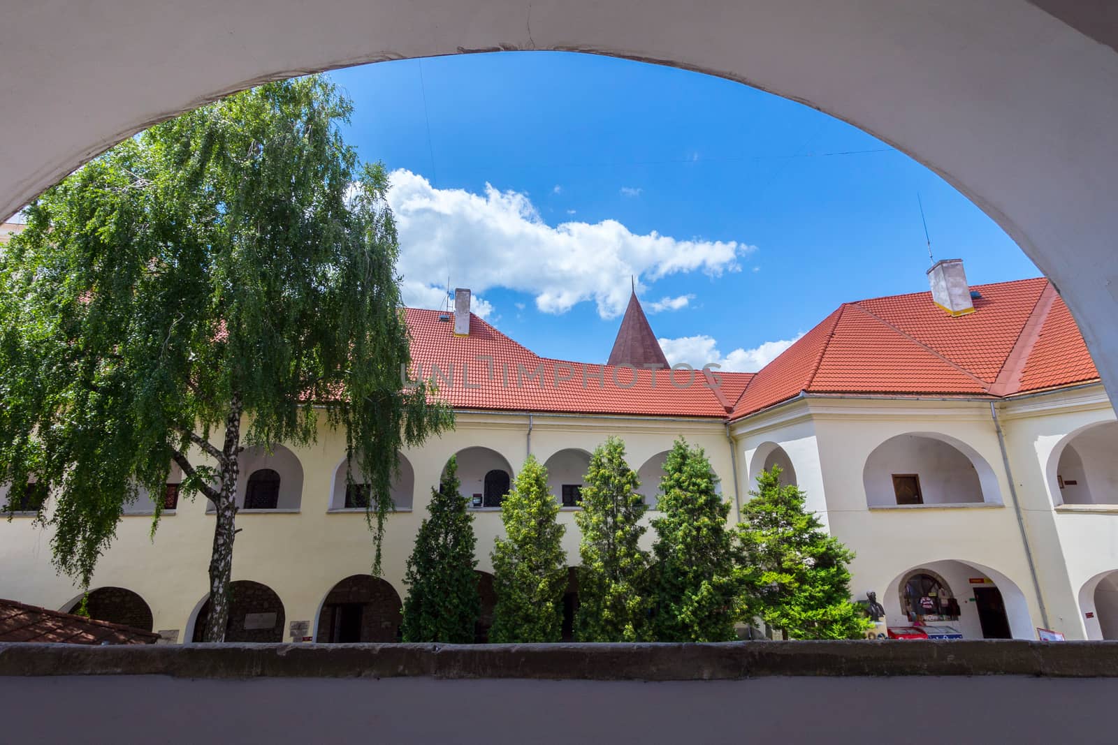 View from the window to the nearest building of an old castle with a red roof