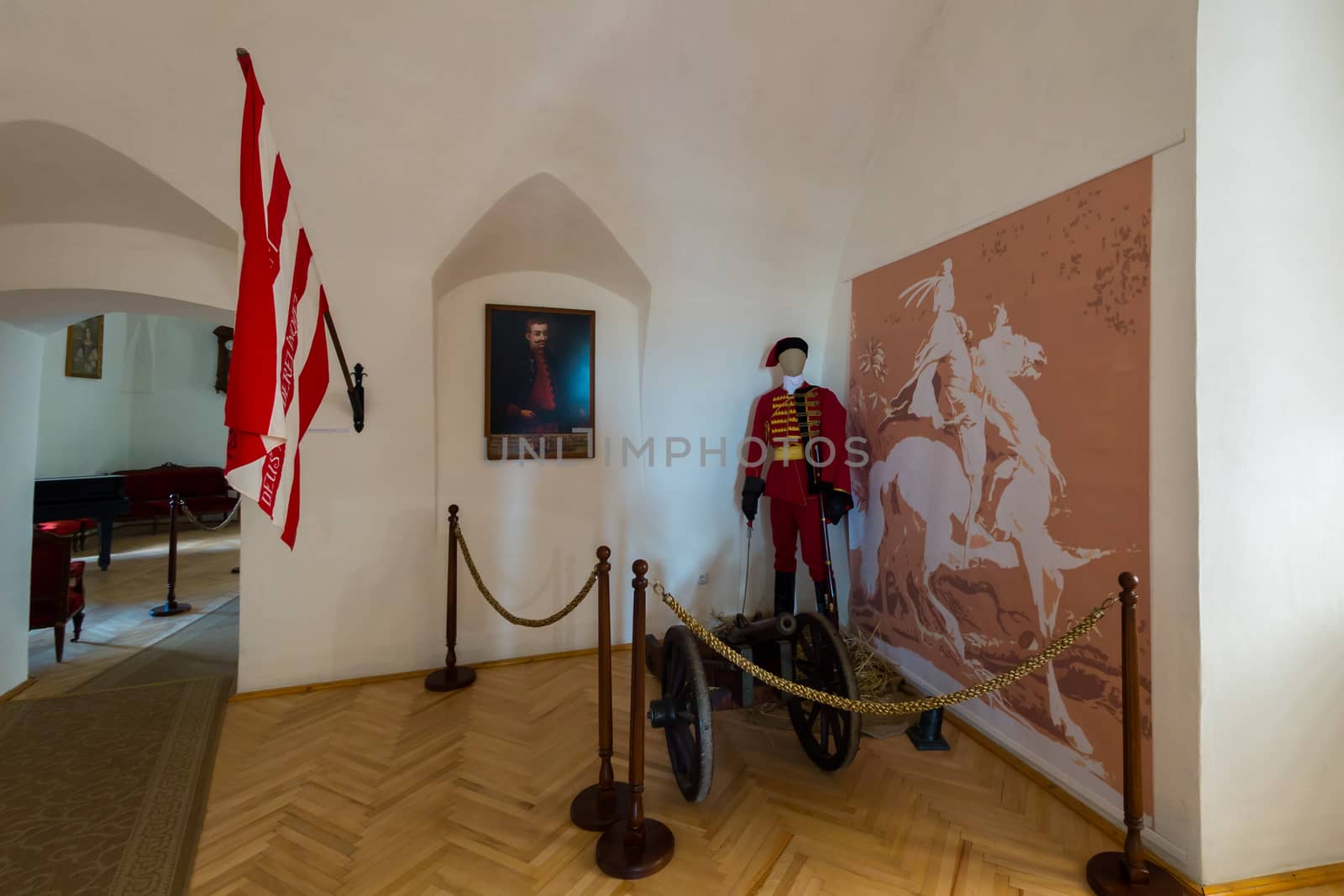 Fenced museum exposition depicting a soldier of the Middle Ages guarding the gun