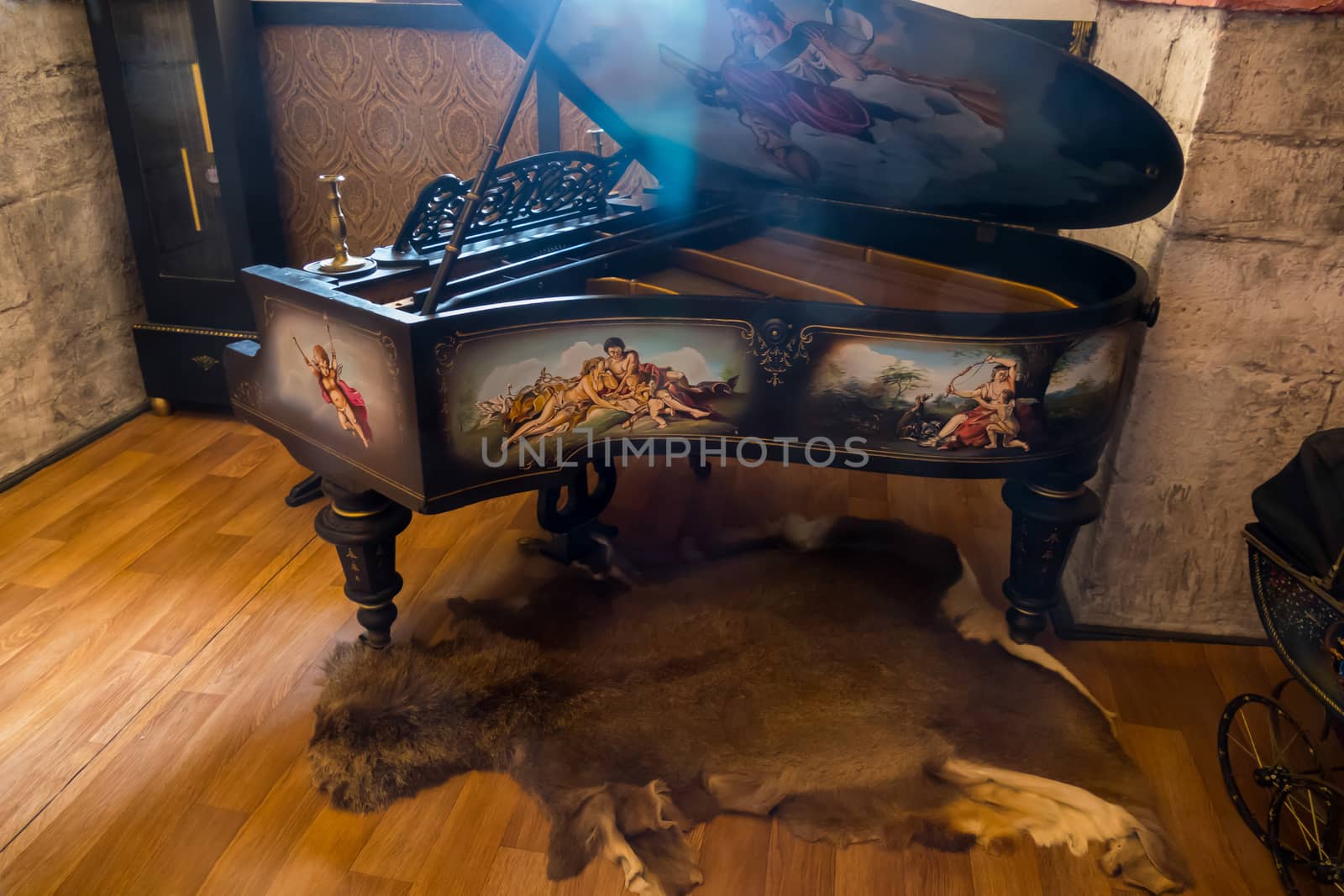 An ancient piano standing on the skin of an animal with pictures painted on its sides