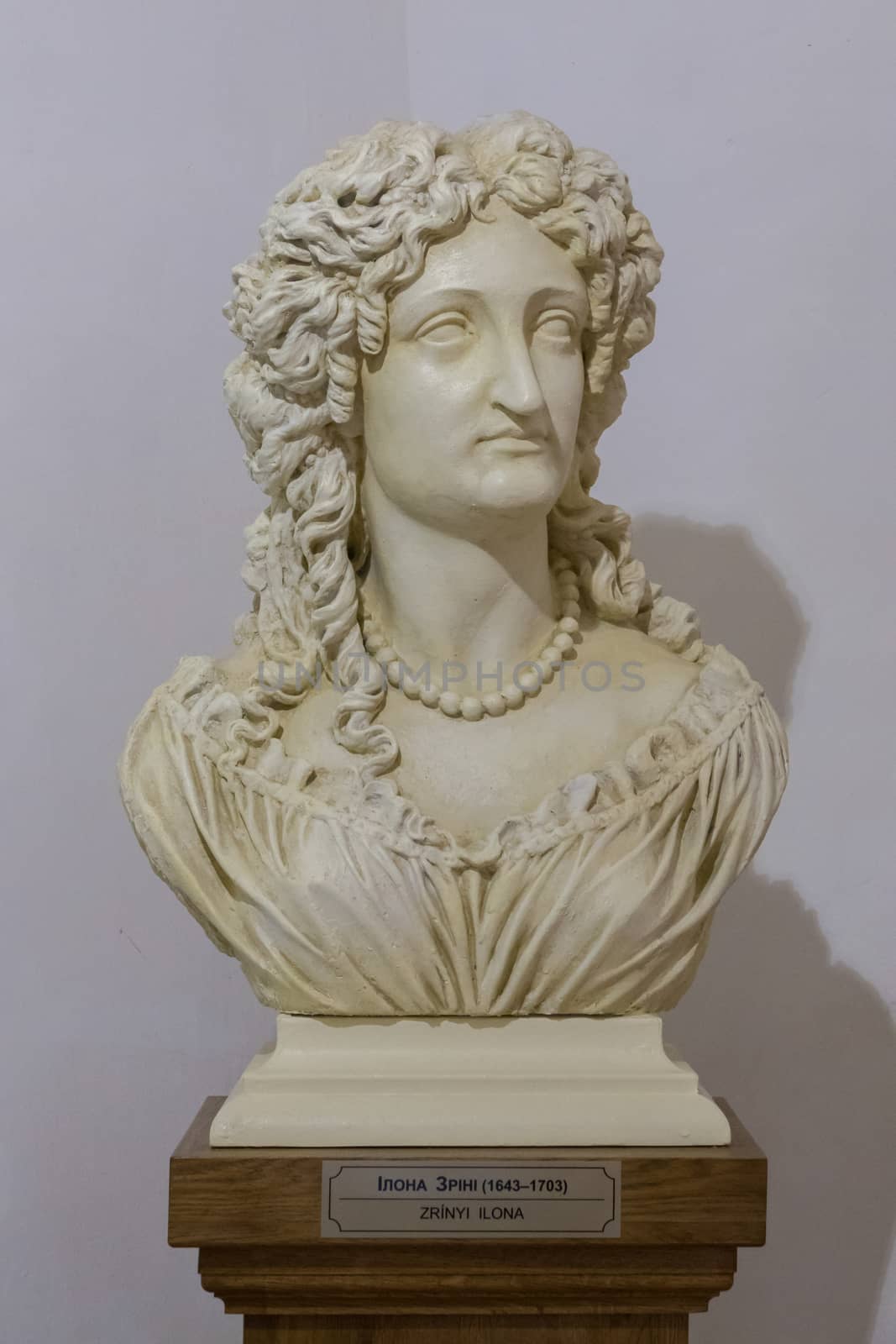 historically a woman's bust in a museum with a commemorative plaque