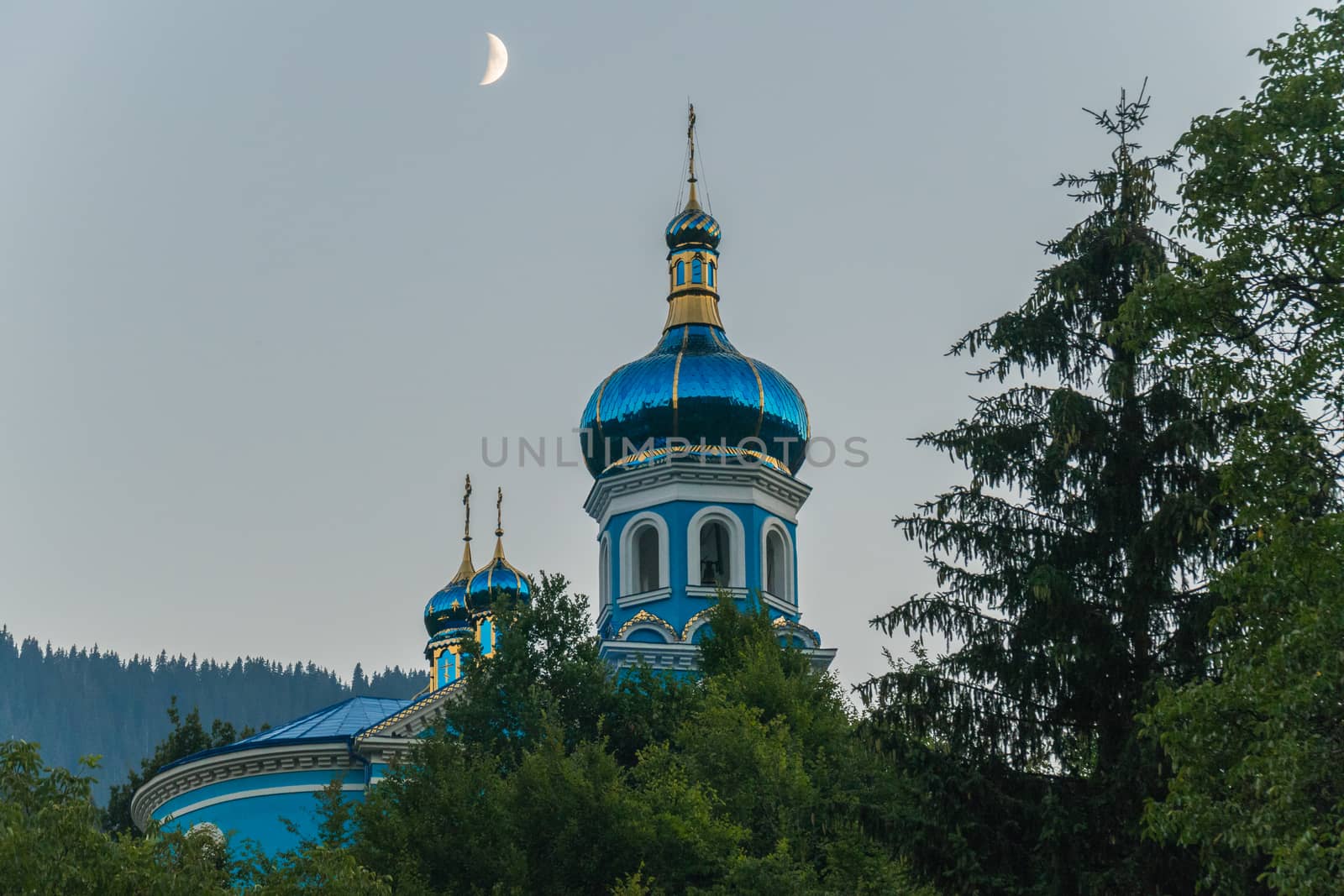 a majestic moon in a cloudless sky above the dome of the church