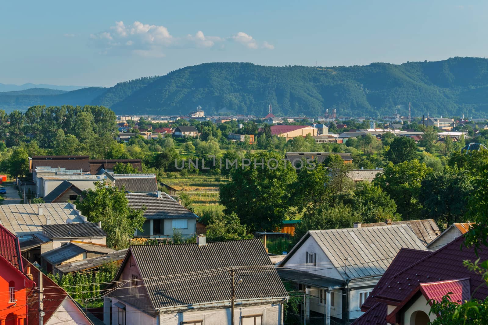 Imbuedly floating clouds above the green tops of the mountains and sleepy city
