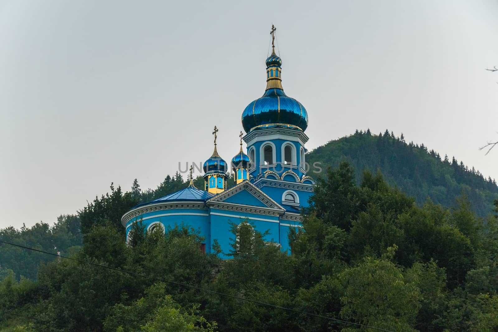 emerald turquoise tops of churches drowning in lush foliage of trees