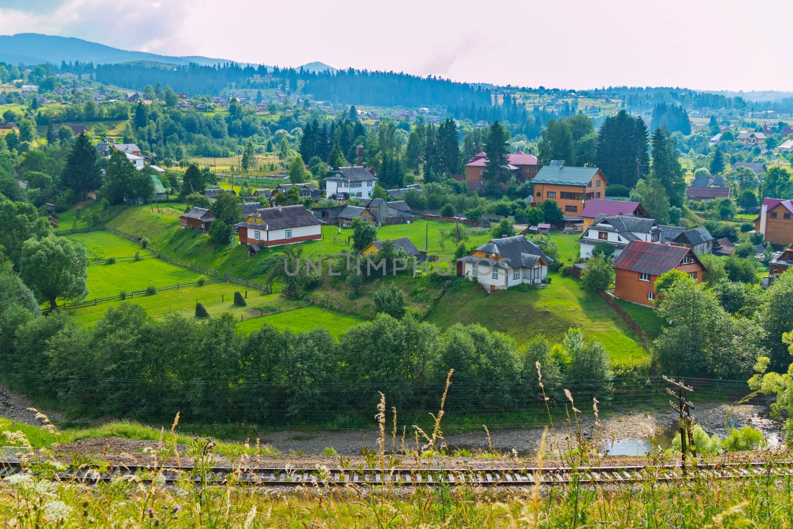 beautiful and well-kept houses on green grass carpets in a mountain valley