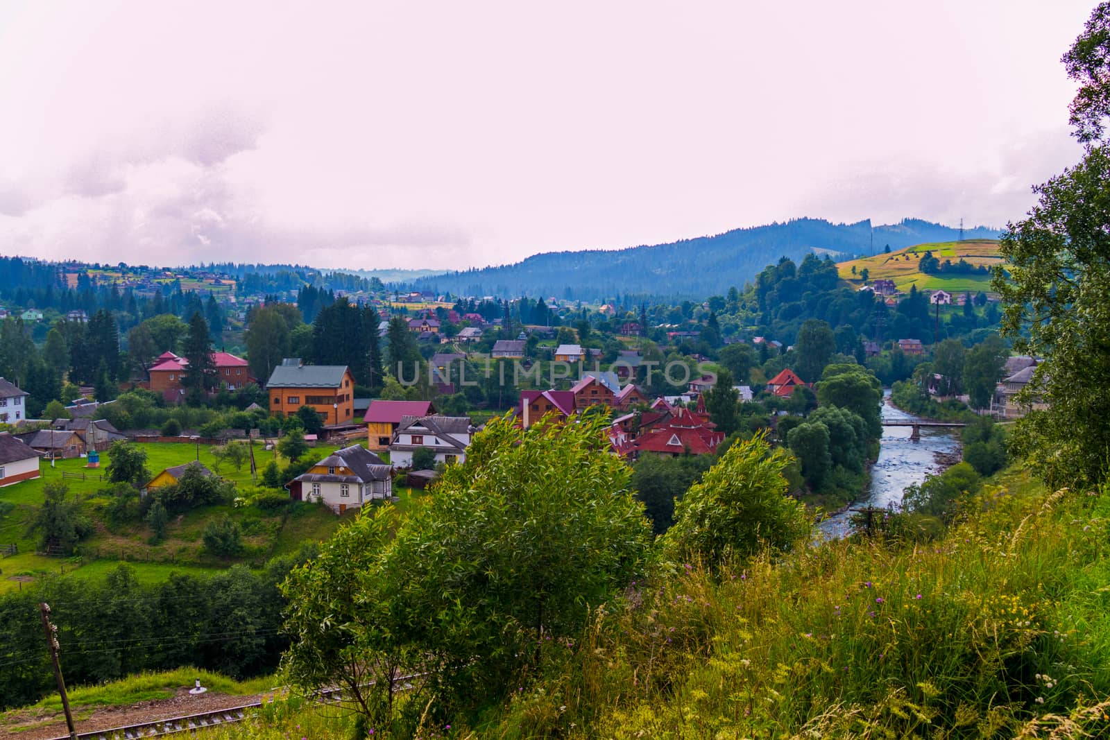 railway with a view of the river and the bridge in the background of a mountain village