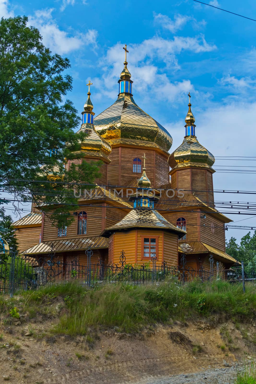 superb wooden church shining with gold domes on a background of blue sky