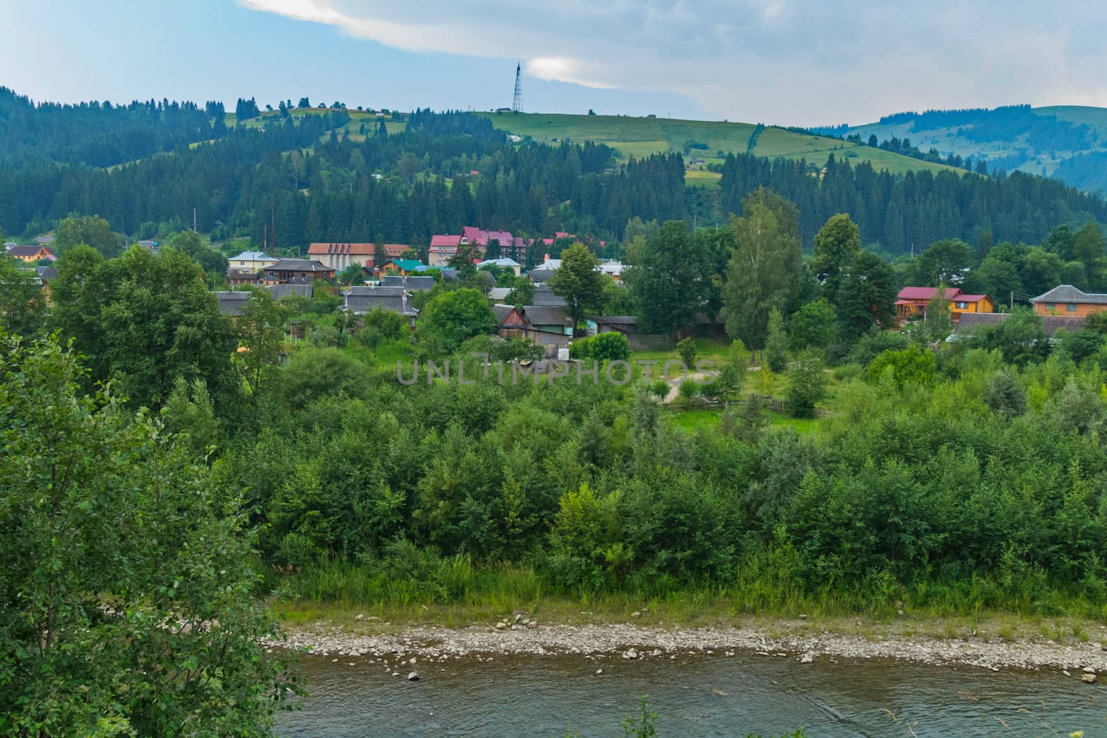 the flow of the river with stony shores near the resort town, located at the foot of the hill