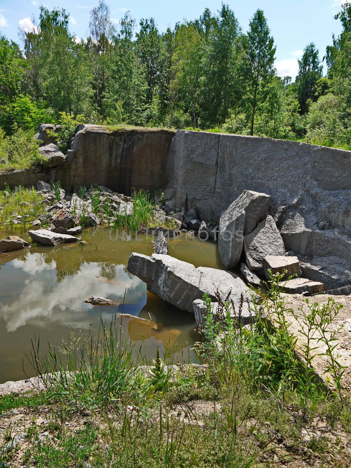 stones lying in the form of a dam blocking the path of water in a small fishing line