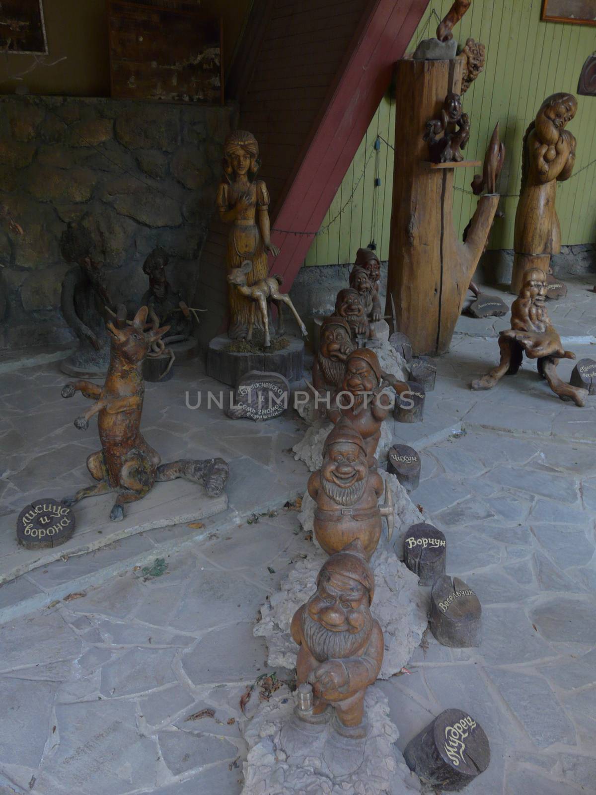 various beautiful wooden statues and seven dwarves lined up in a row