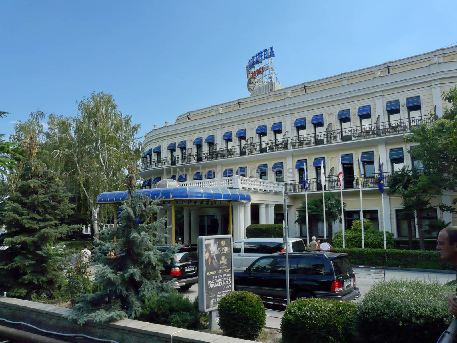 The hotel has a beautiful facade and a blue canopy from the rain and sun
