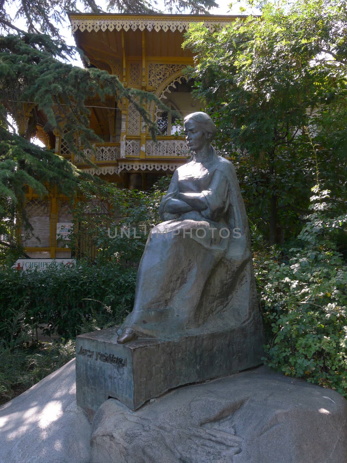 monument of a woman sitting with a pensive face carved out of a  by Adamchuk