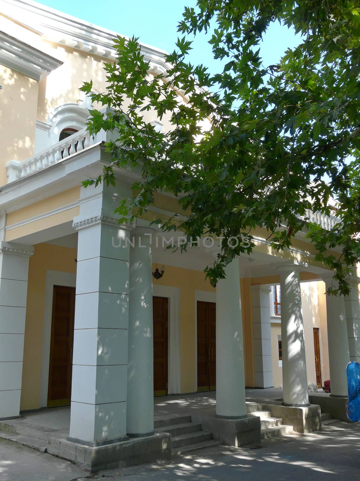 Steps leading to the entrance to the yellow building with huge white columns and pillars