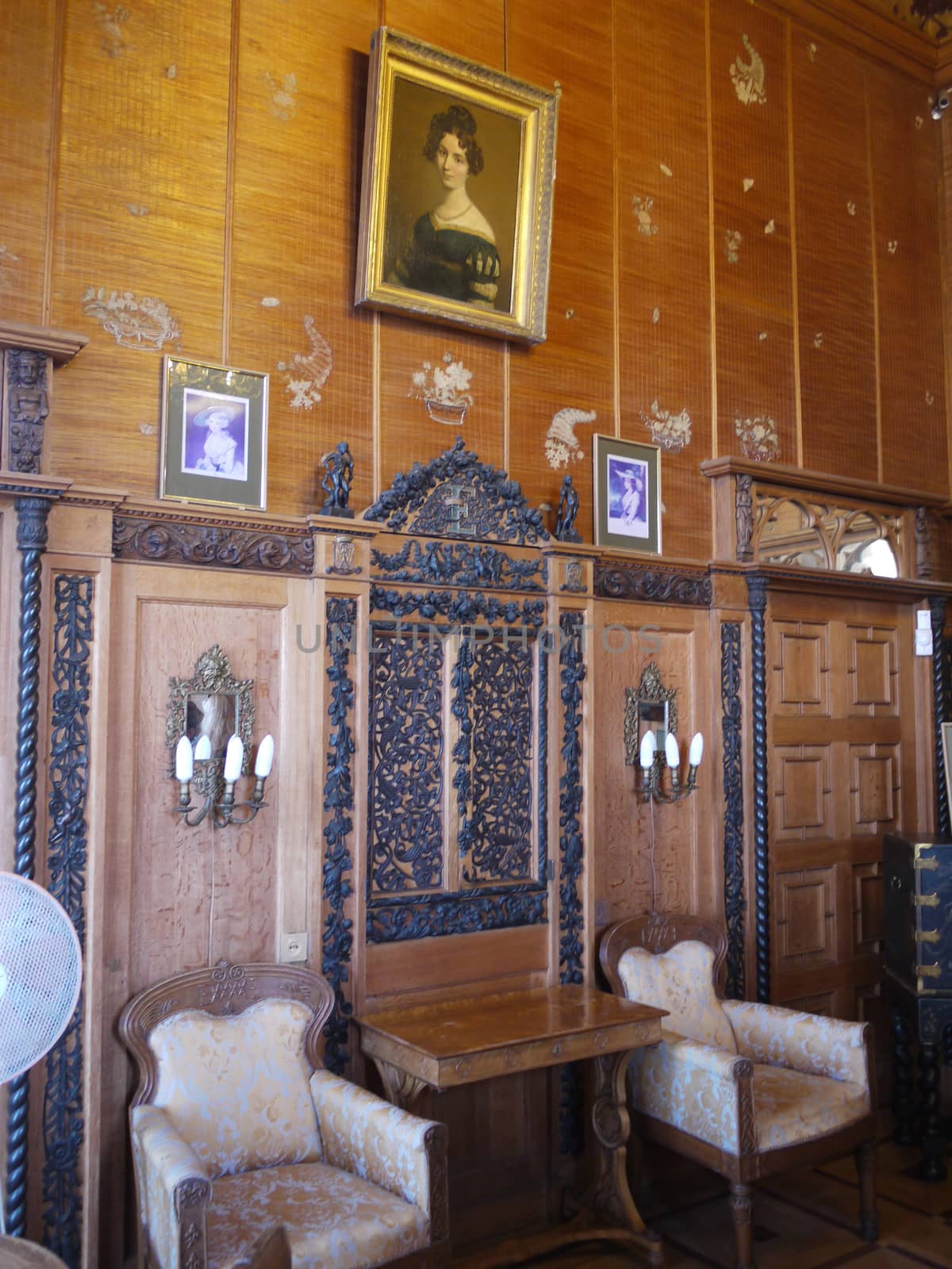 room with a woman's portrait and beautifully decorated wooden walls in the estate