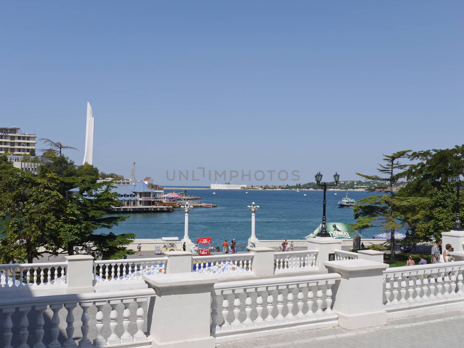 embankment with a white fence against a calm blue sea