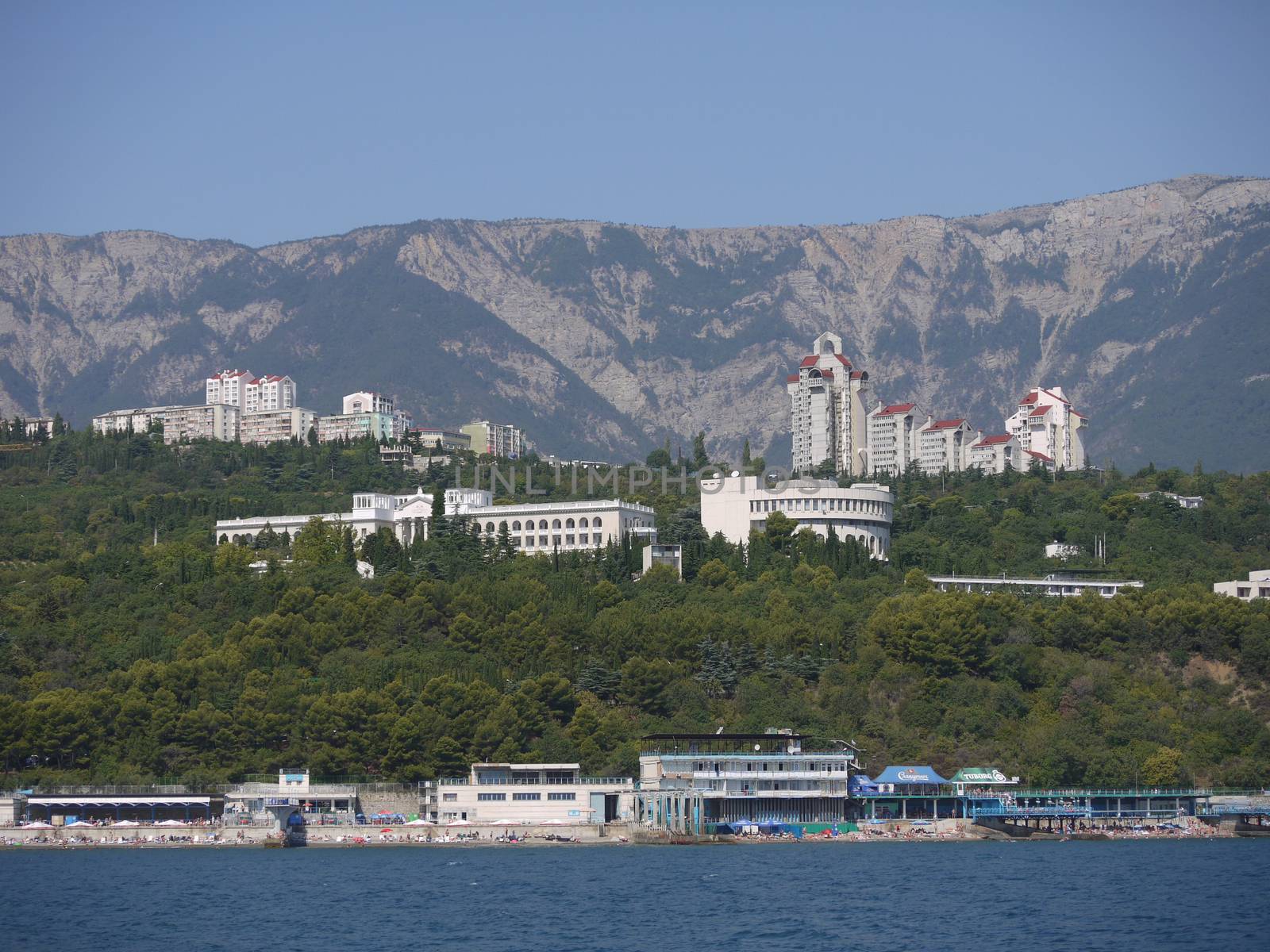 panorama of rocky peaks from the foot and large white houses near the sea