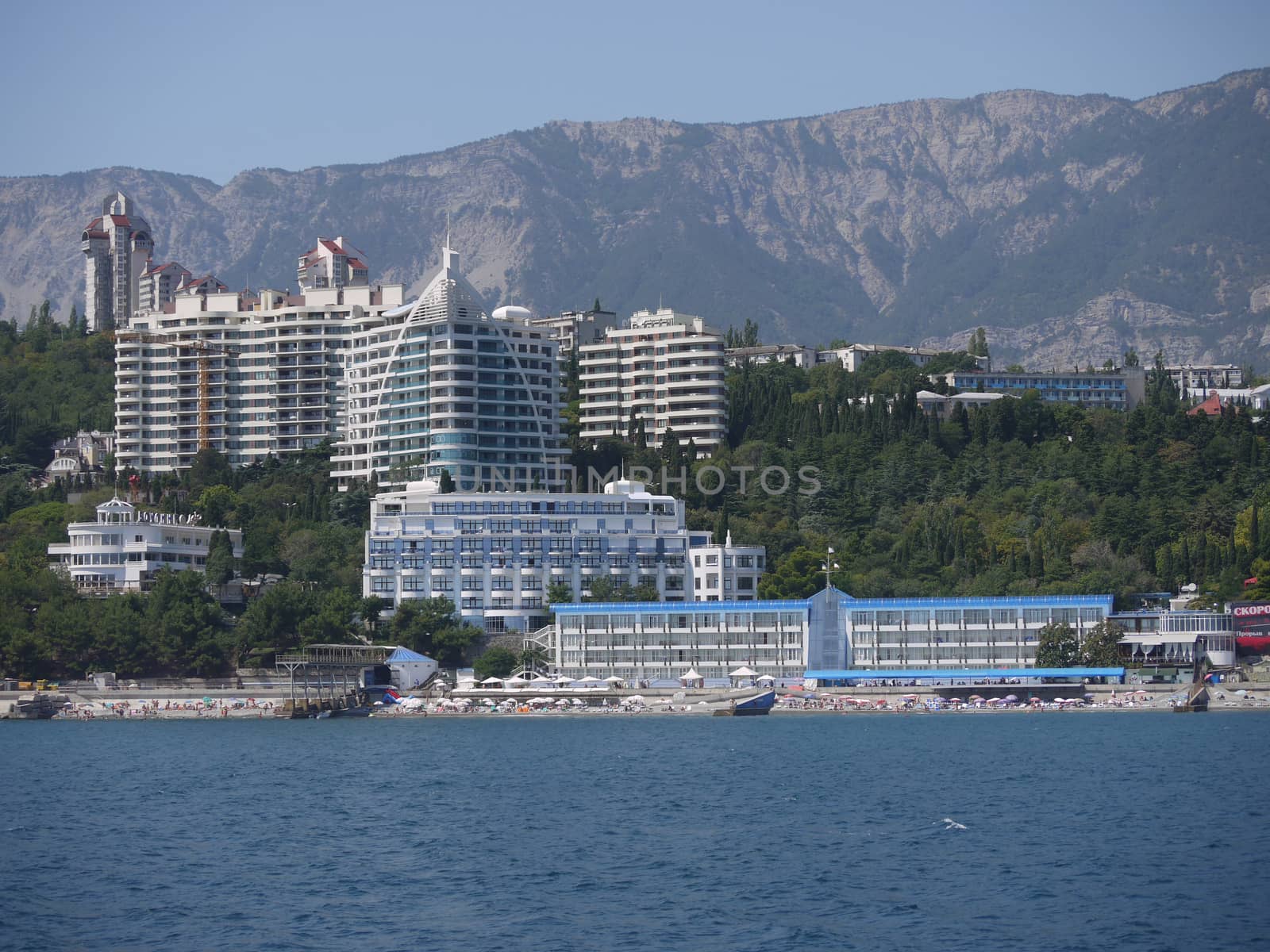 Modern seashore with skyscrapers and a beach and mountains in the background. Every tourist wants to relax there and sunbathe