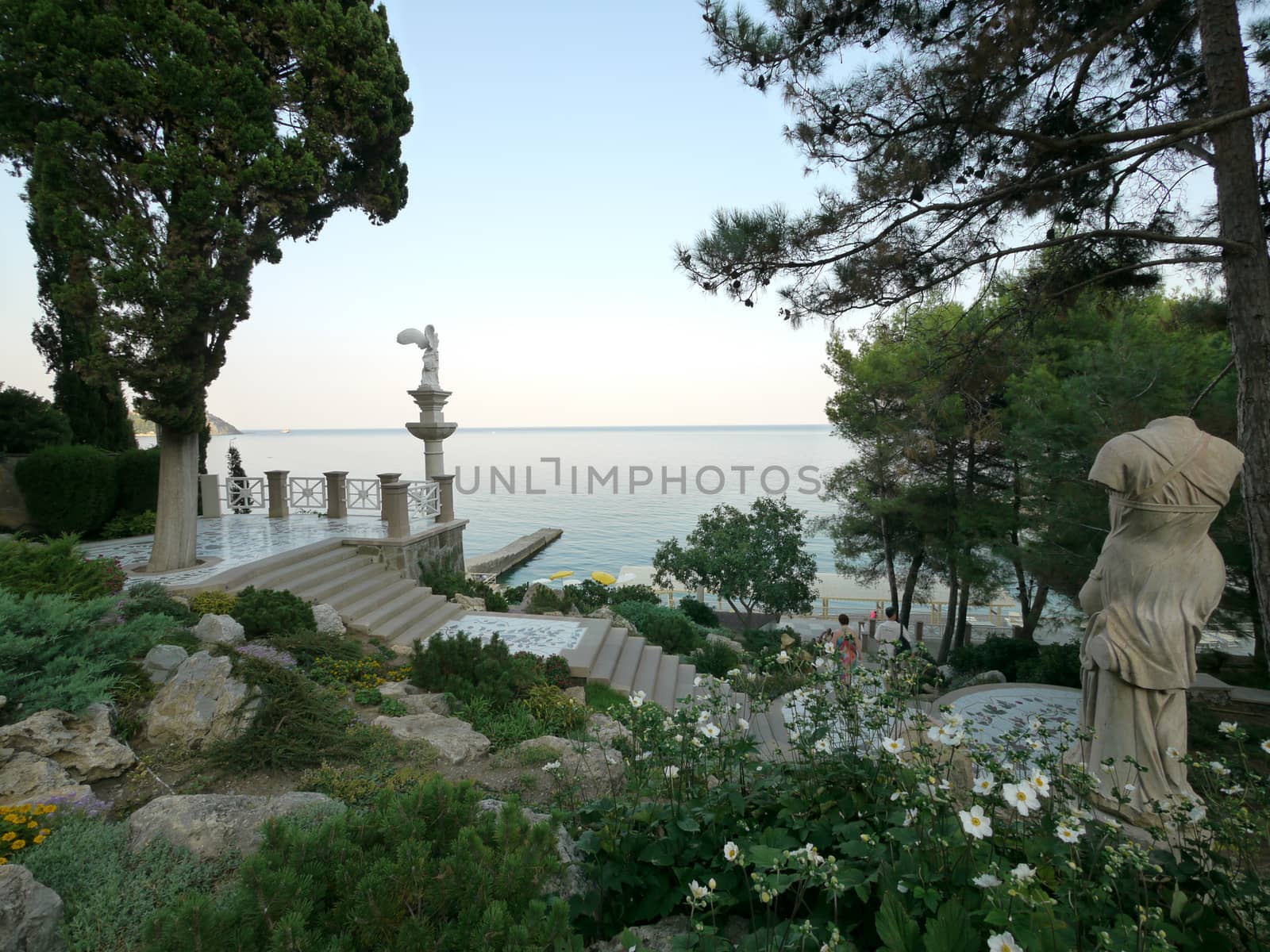 A view of the vast sea water from the park with standing sculptures and beautiful steps of the stairs