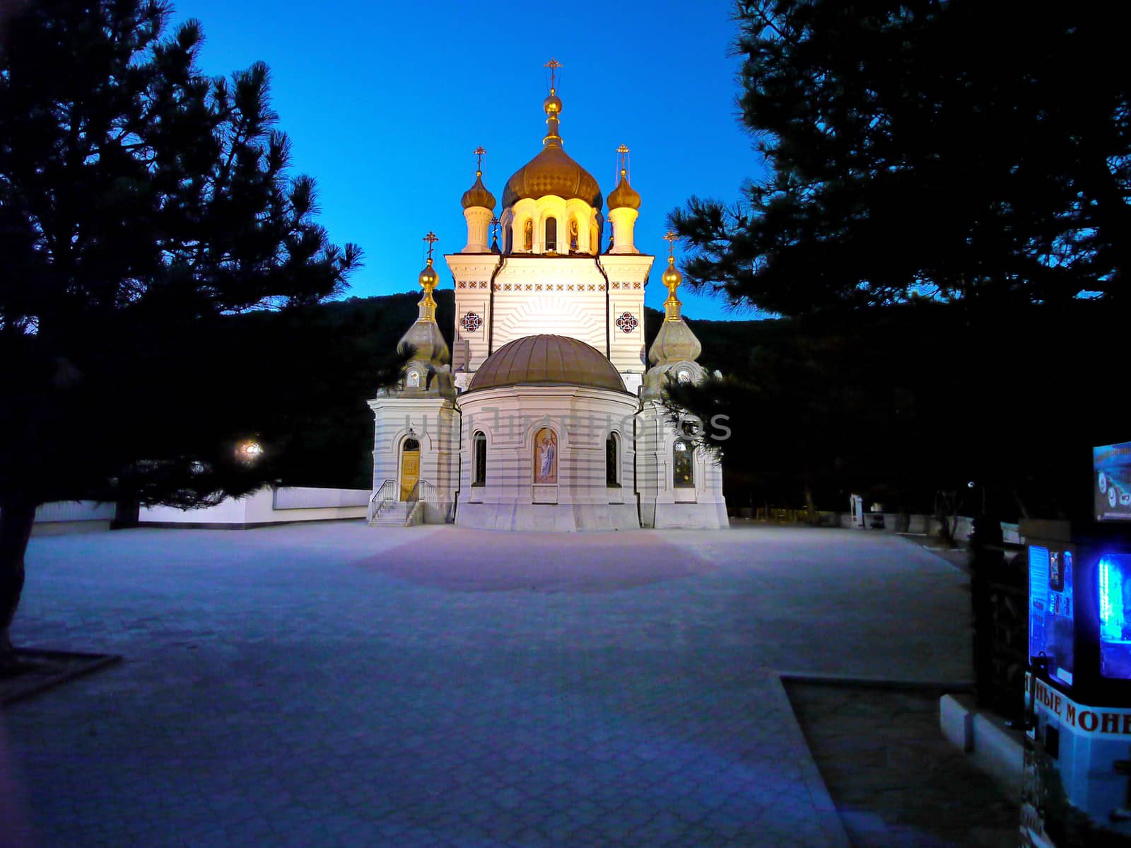 A tiled alley leading to a beautiful church church lit by lanterns