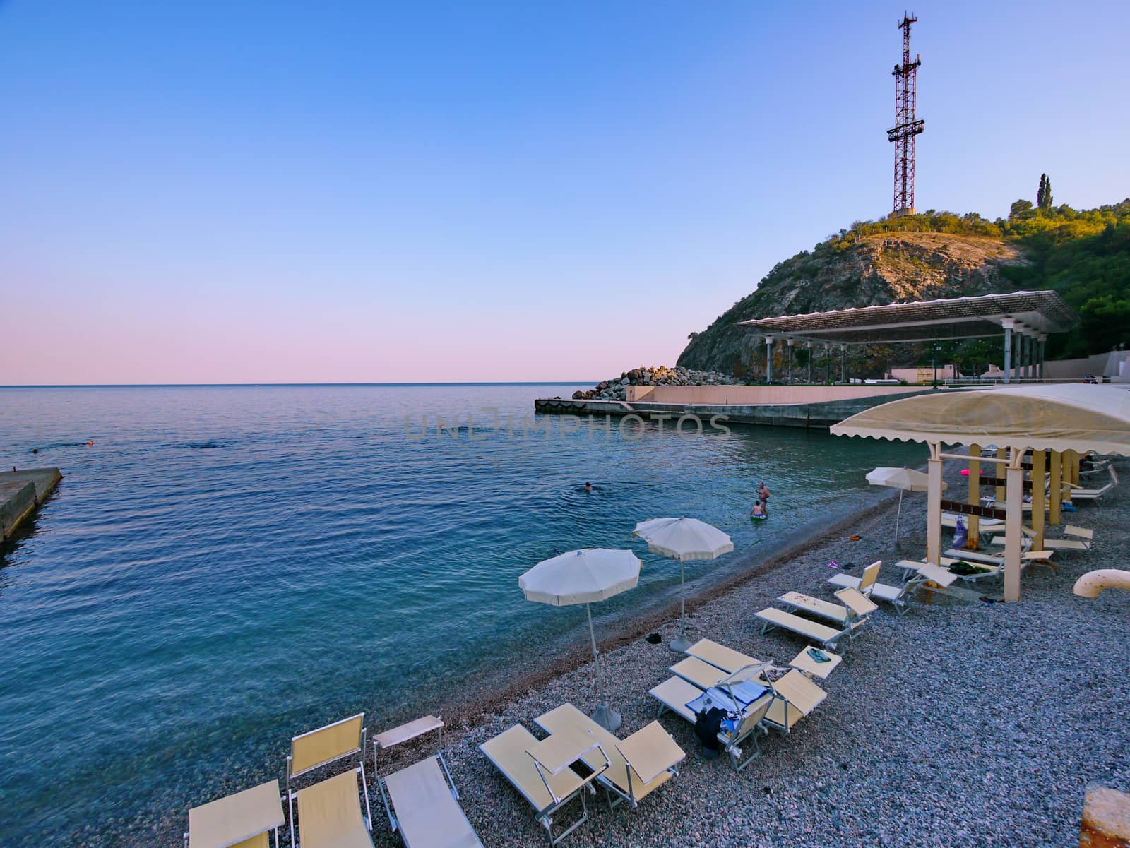 Comfortable beach on the sea coast with sun beds, umbrellas and a special cover for tourists