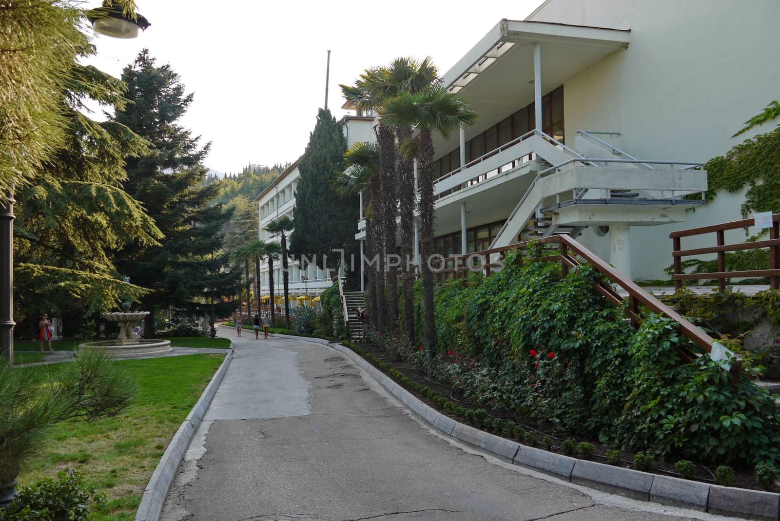 A promenade with tourists near one of the buildings of the hotel complex