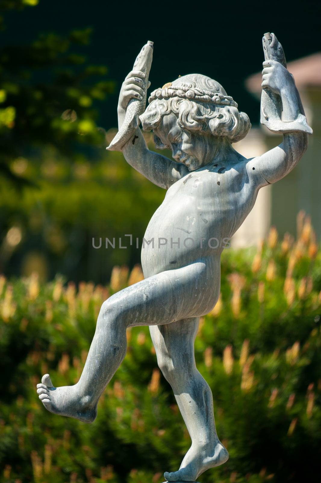 A statue of a naked little boy with two fish in his hands