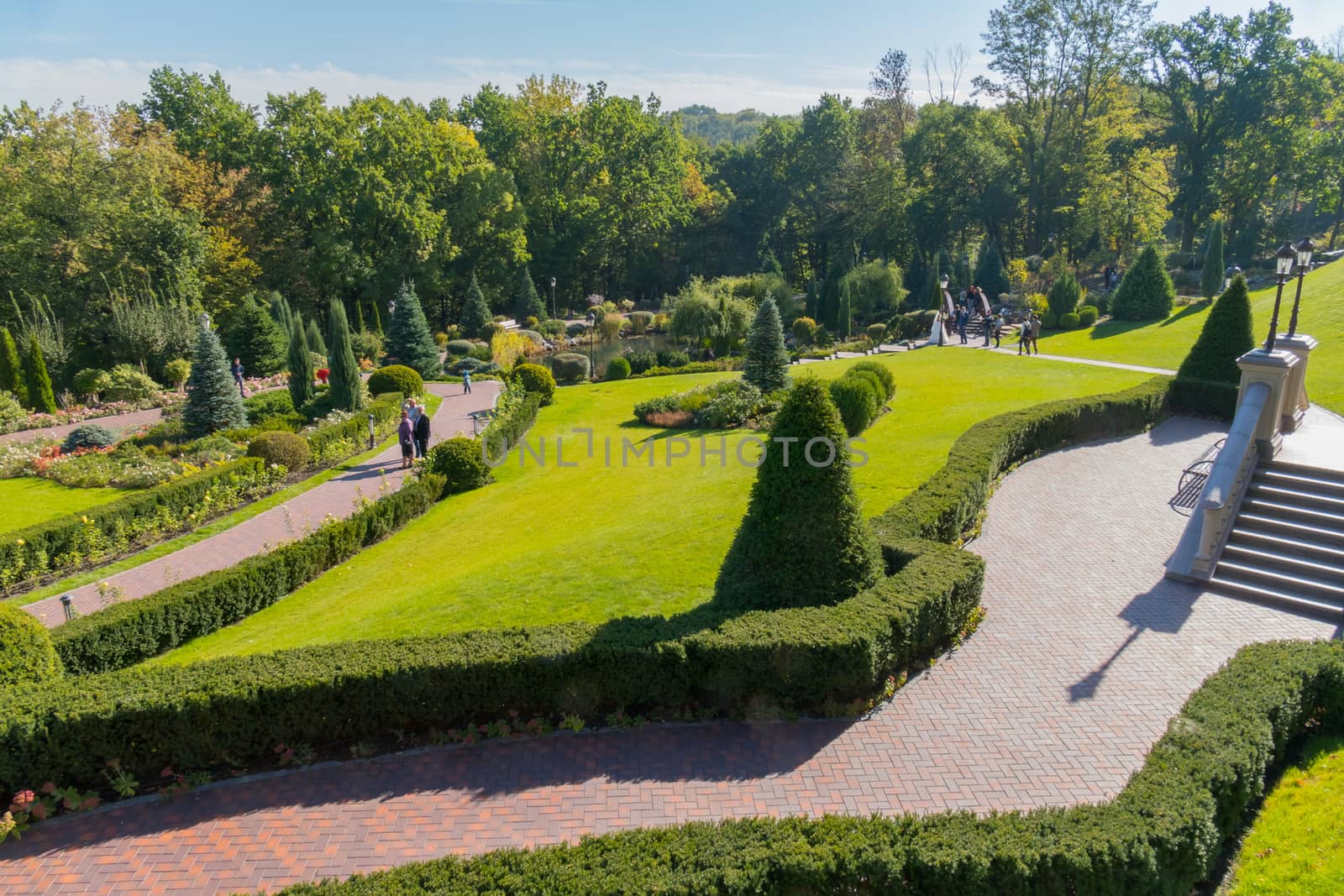 A panorama of the park with beautiful landscape design made of shrub shrubs, flowers and green lawns. Mezhygirya Ukraine