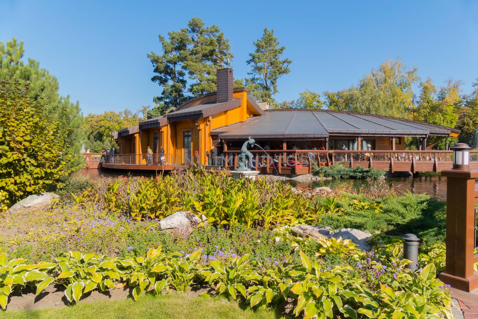 a cafe with a summer terrace located in a picturesque location amidst green vegetation