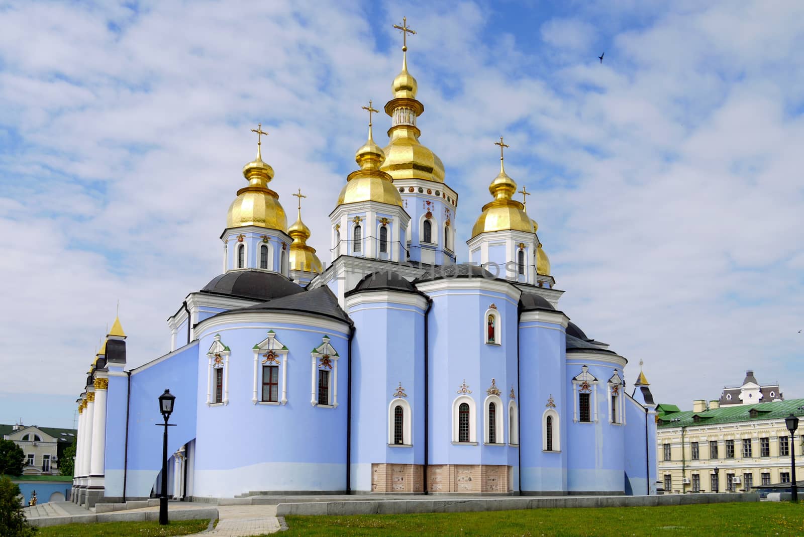 a lonely bird hovering in the blue of the sky above the golden domes of the church