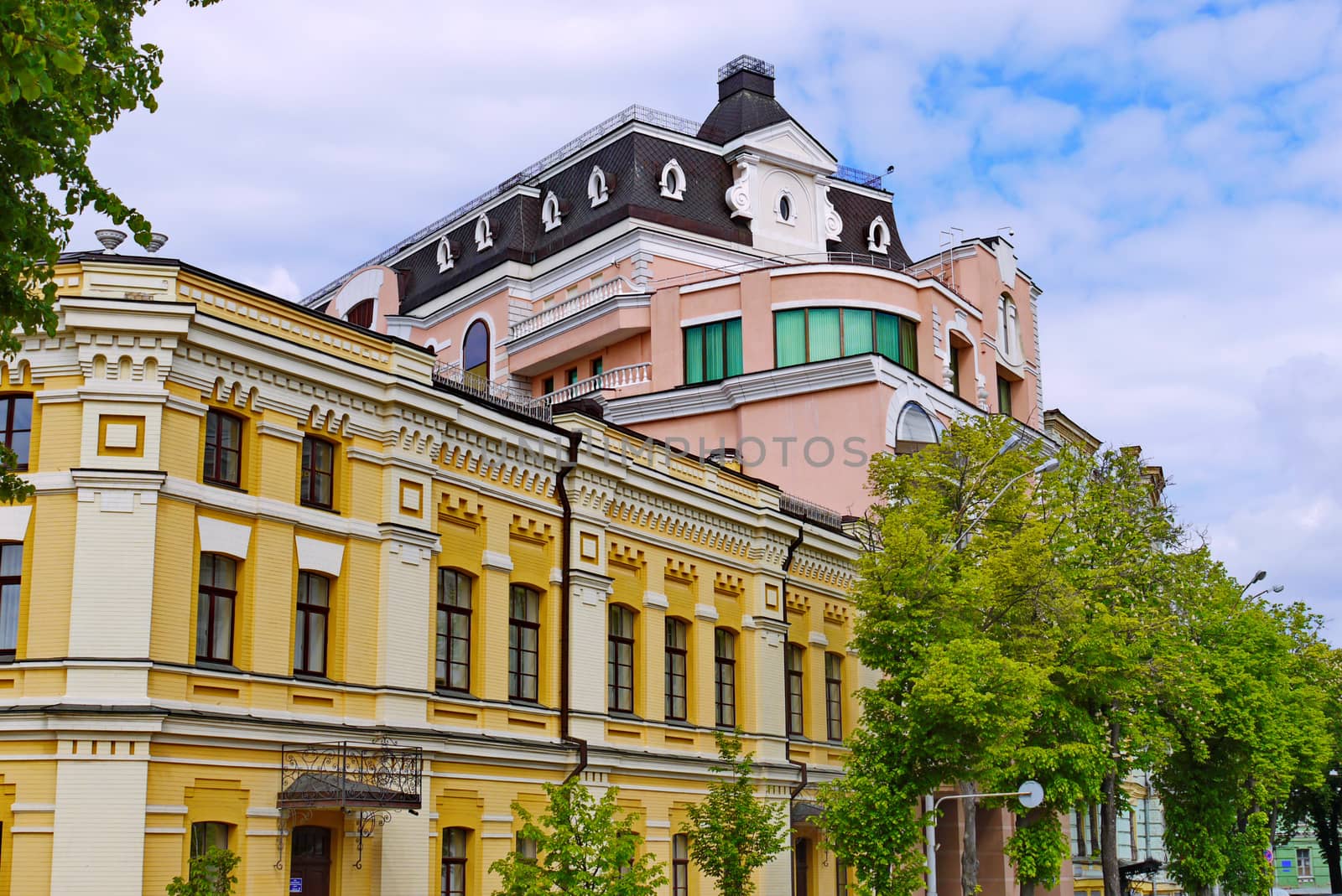 Street with several beautiful modern buildings against a blue sky with small white clouds