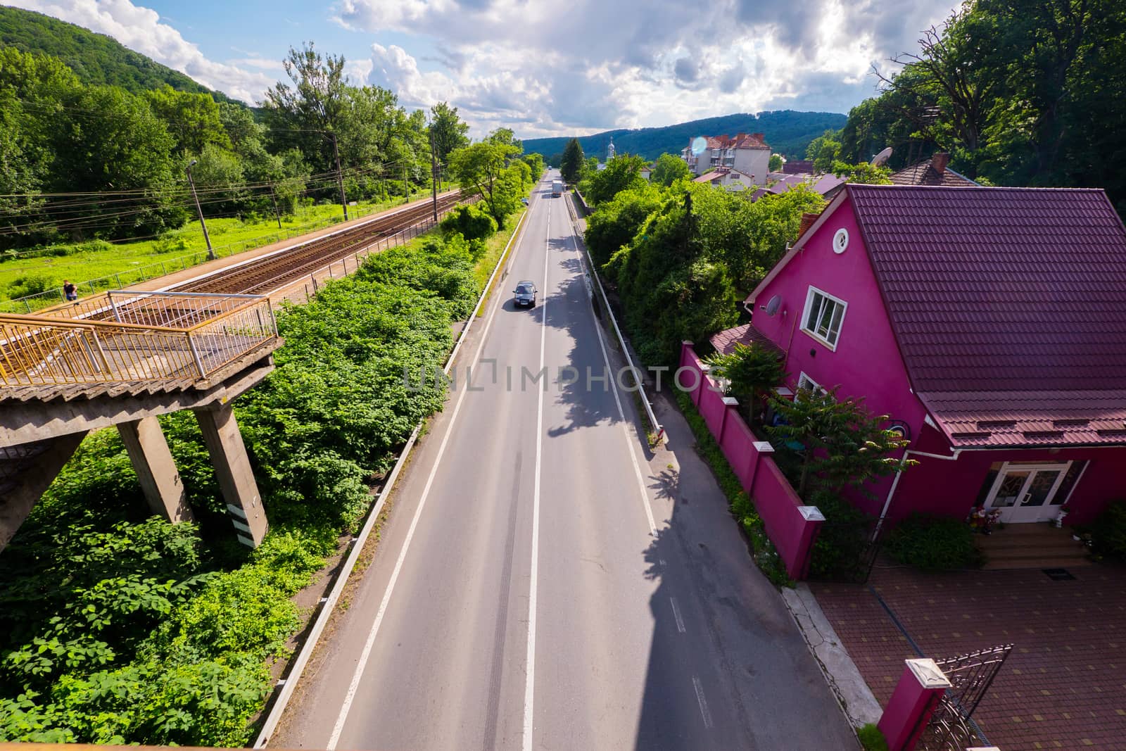The road passing by a bright, purple house. Iron pathways have settled down