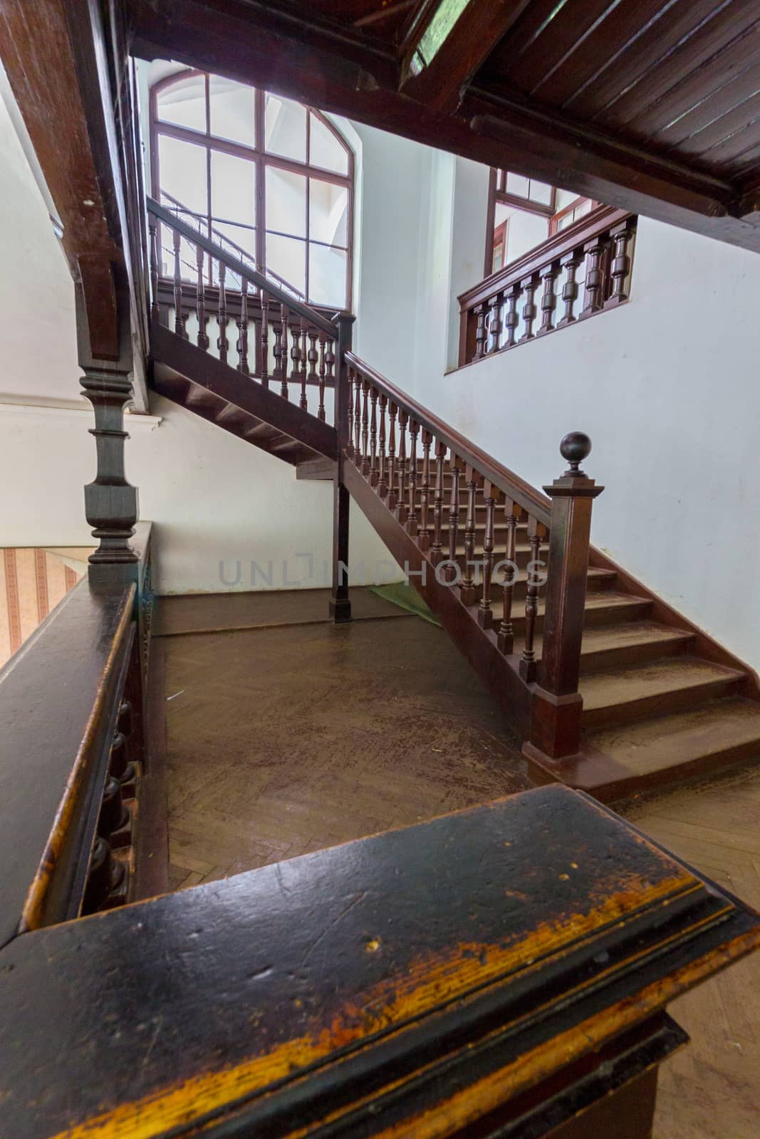 Beautiful old wooden staircase with ornamental handrails leading to the upper floors of the house