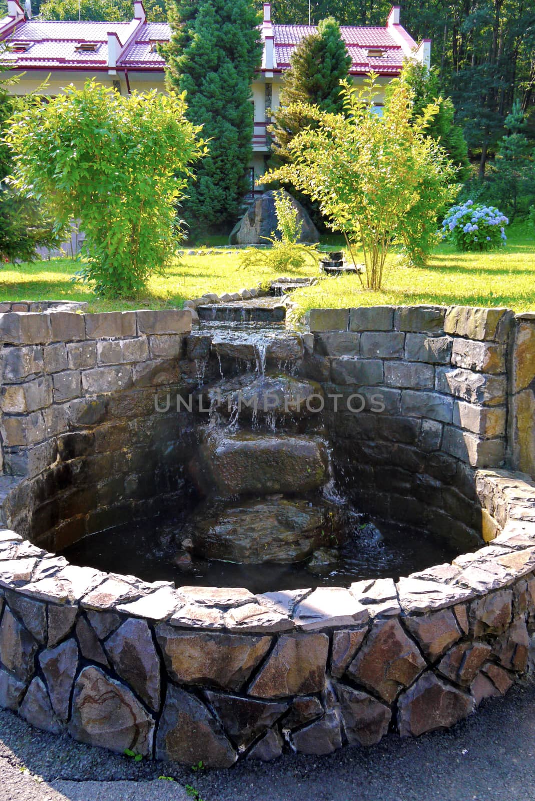 The spring is surrounded by a stone and turned into a fountain. The water flows beautifully down the stairs