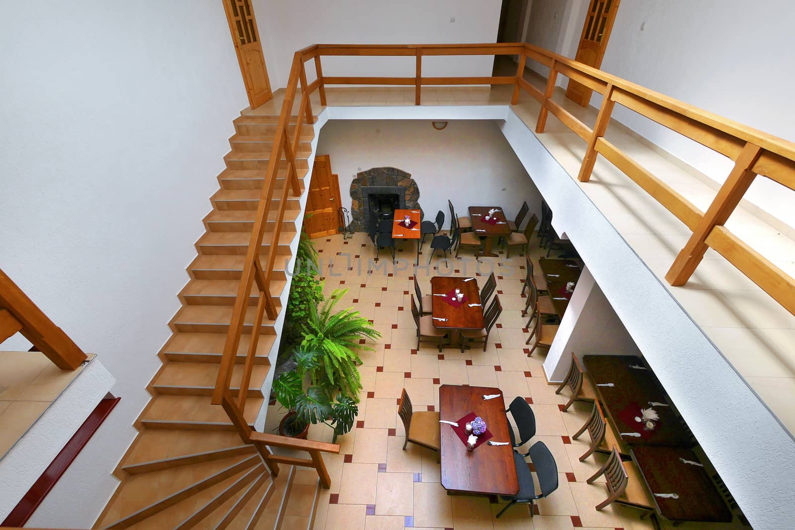 view from above to the banquet hall with tables chairs from the stairs with wooden banisters going down