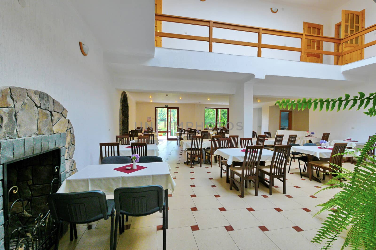 Banquet hall on the first floor with a decorative fireplace. With a beautiful interior and view through the glass doors to the picturesque nature outside the window.