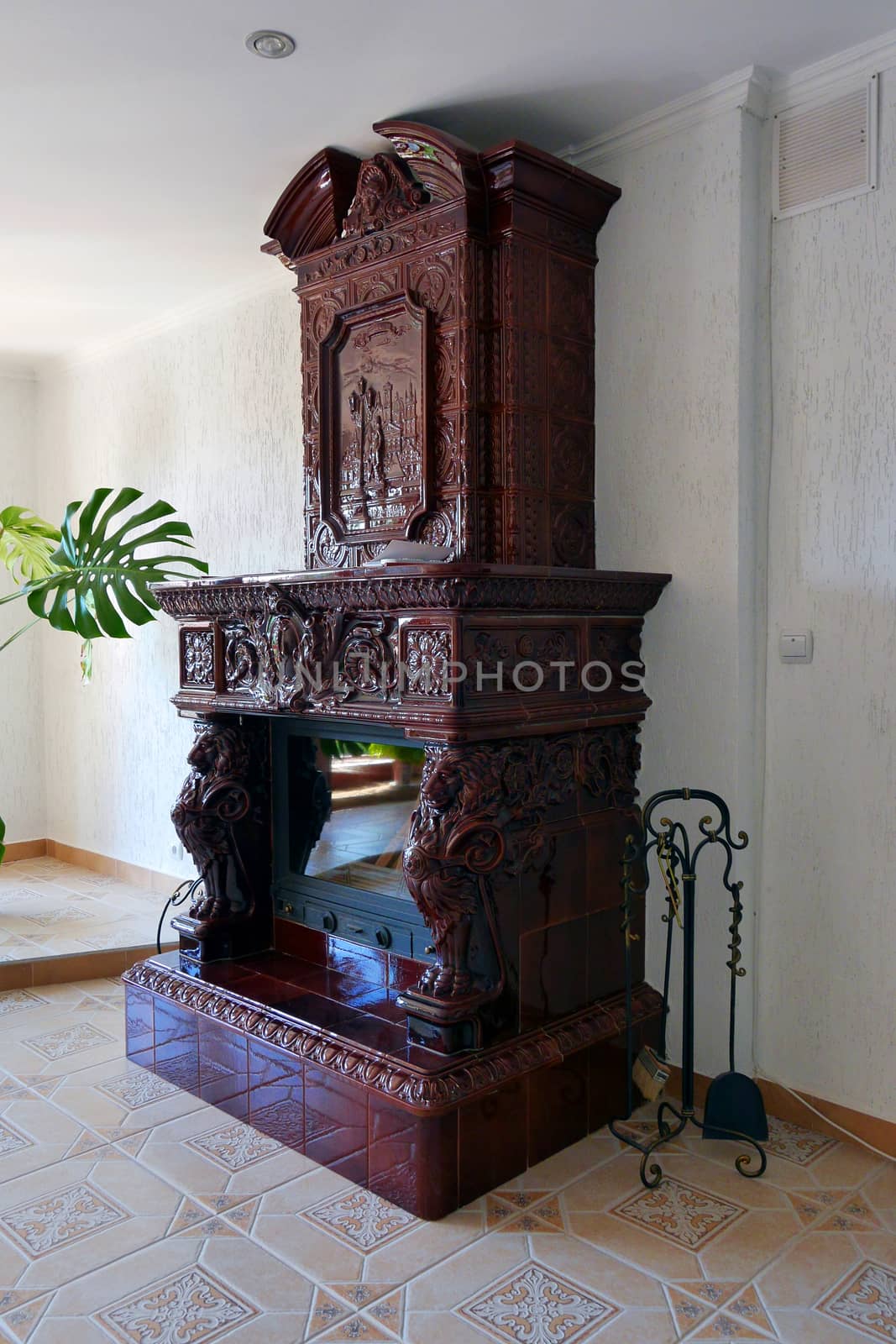 Beautiful stone decorative fireplace with a scoop and brush for cleaning coals by Adamchuk