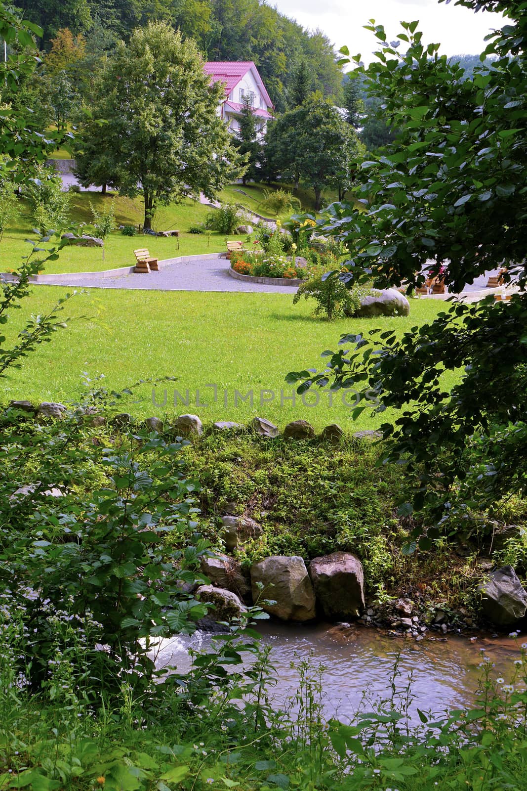 A cozy hotel complex with a smoothly trimmed lawn and a nearby river