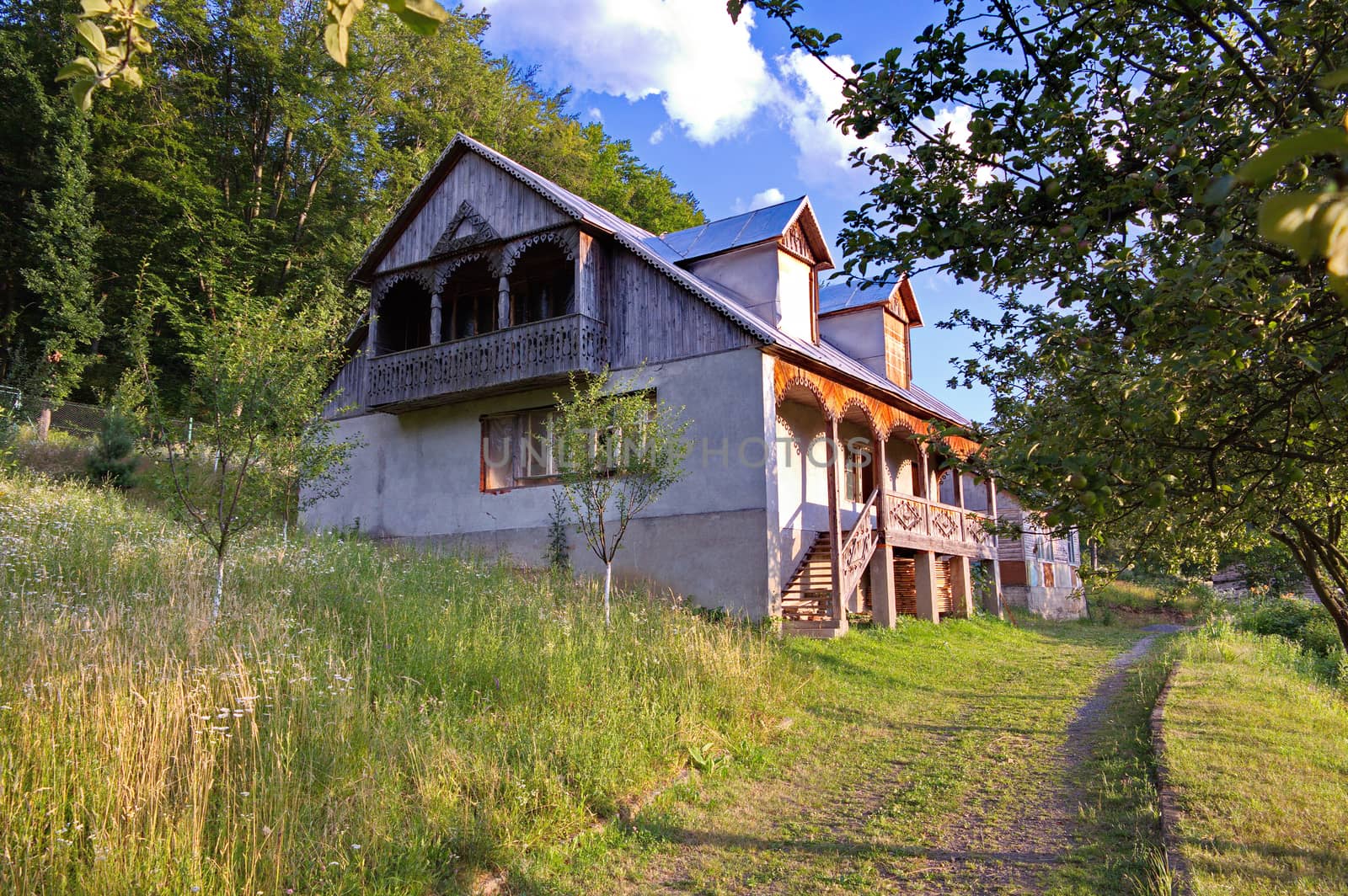 two-storey house with carved balcony and porch in the village